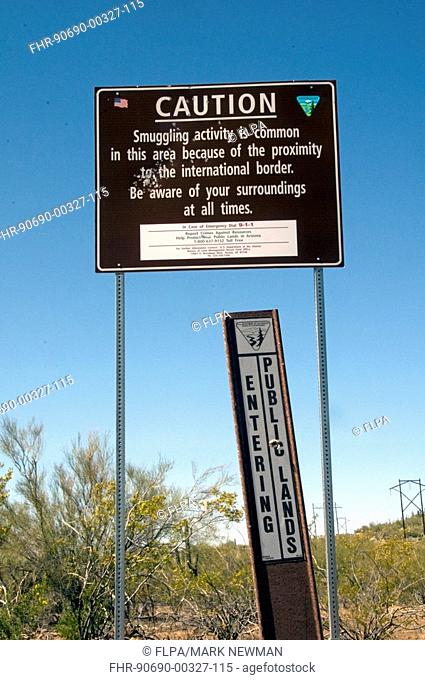 'Caution, smuggling activity' and 'Entering Public Lands' signs in desert, Ironwood Forest National Monument, Arizona, U S A