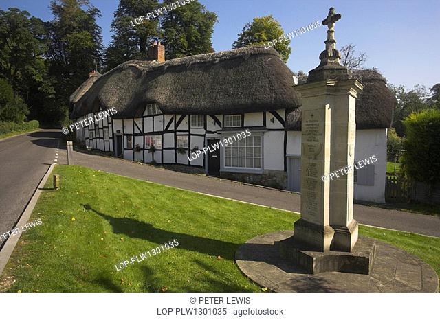 England, Hampshire, Wherwell, A war memorial by thatched cottages in the village of Wherwell near Andover in Hampshire