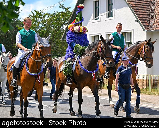 18 June 2023, Brandenburg, Casel: Tobias Richter, who is St. John this year, rides to the festival site decorated with cornflowers and a crown of flowers