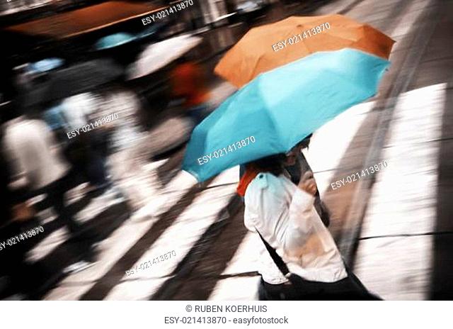 Two women under umbrella crossing