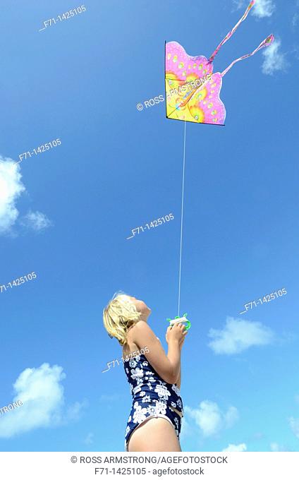 Six year old girl flying a kite at the beach  Mimiwhangata, Northland, New Zealand