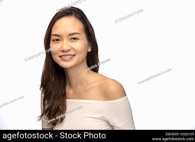 Portrait of young woman of Asian descent looking at camera smiling