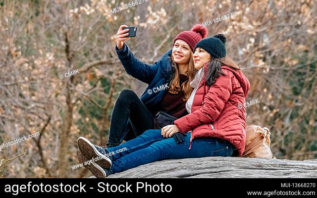 Two girls sit on a rock in Central Park New York - travel photography