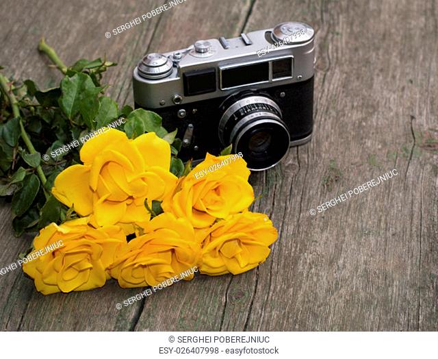 yellow roses and retro the camera behind them on a table