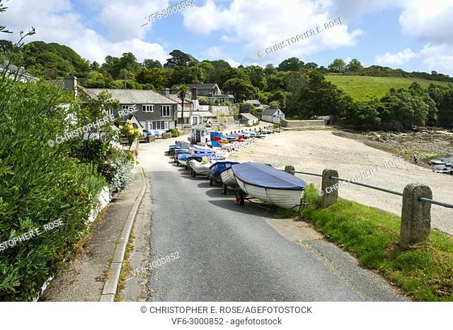 Many colourful small boats line up along the roadside beach edge in the popular launching place of Helford Passage, Cornwall, UK