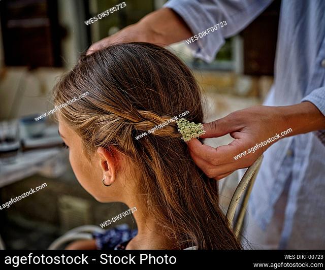 Woman adjusting flower in daughter's hair