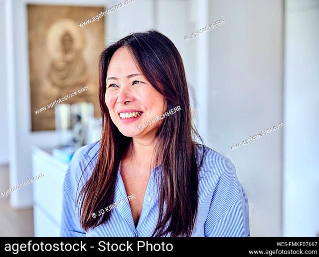 Happy mature woman with long hair at home
