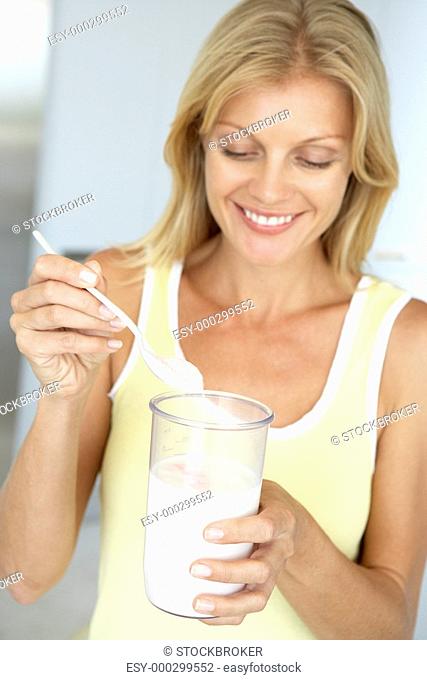 Mid Adult Woman Holding Dietary Supplements