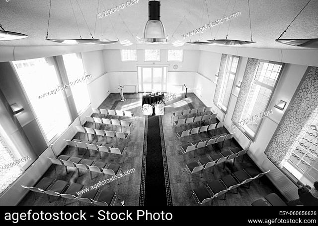 A wedding reception hall with chairs laid, awaiting the arrival of the guests and couple of bride and groom, black and white