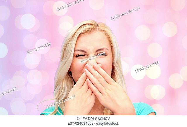 emotions, expressions, embarrassment, and people concept - young woman or teenage girl wrinkling and closing her nose of unpleasant smell over pink holidays...