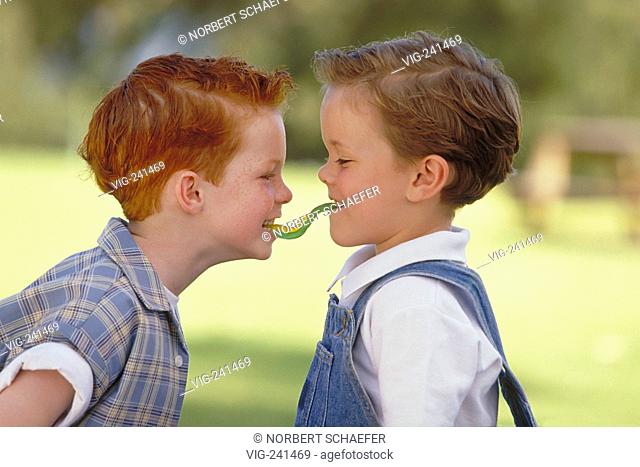 park-scene, portrait, close-up, 6 years old redheaded boy with freckles and his friend in the same age, both wearing checked shirts