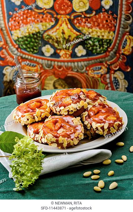 Apple fritters topped with jam and flaked almonds