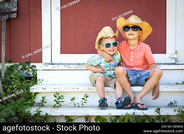 Mixed Race Chinese and Caucasian Young Brothers Having Fun Wearing Sunglasses and Cowboy Hats