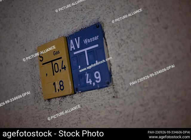 26 September 2023, Berlin: Signs point to gas and water lines on a service connection in an apartment building. The energy industry has warned of new price...
