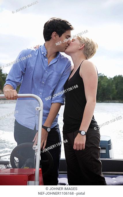 Young couple kissing on boat