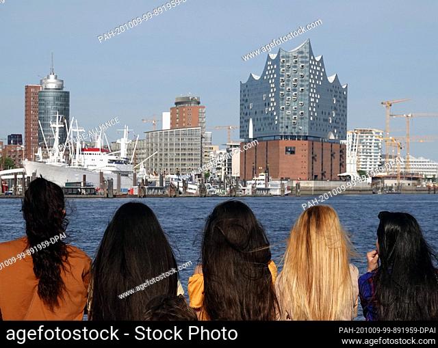 16 June 2020, Hamburg: Five young girls with long hair look from a barge in the direction of Hafencity and the Elbphilharmonie Concert Hall