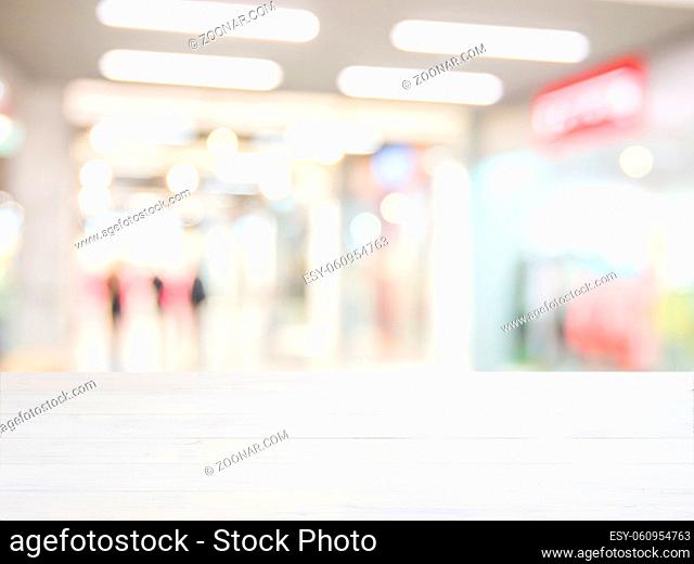 White wooden board empty table in front of blurred background. Perspective white wood over blur in shopping mall - can be used for display or montage your...