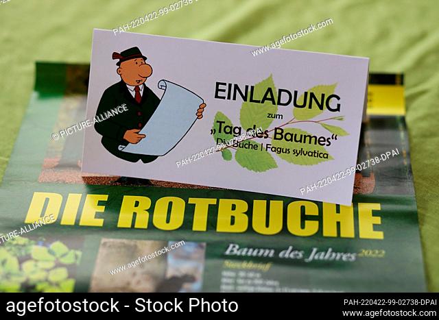 22 April 2022, Saxony-Anhalt, Silberhütte: An invitation card for a planting campaign on Arbor Day is on a poster about the copper beech