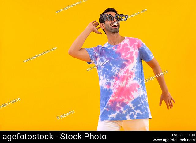 Funny young man in party eye glasses posing in front of camera