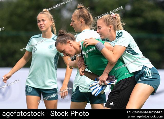 06 July 2022, Great Britain, London: Soccer: National team, women, Euro 2022, training Germany: Almuth Schult (bottom) carries Laura Freigang