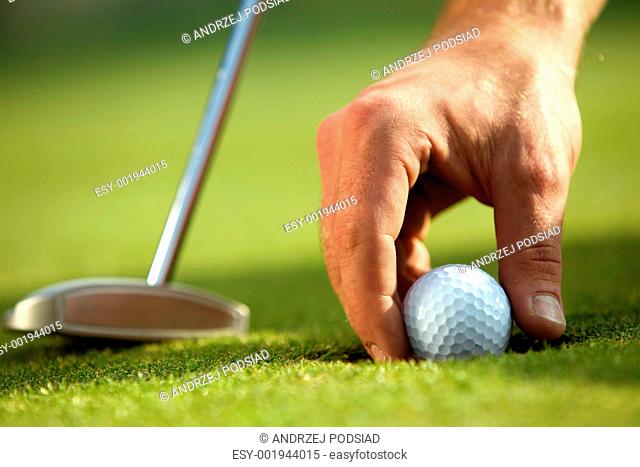 Person holding golf ball, close-up