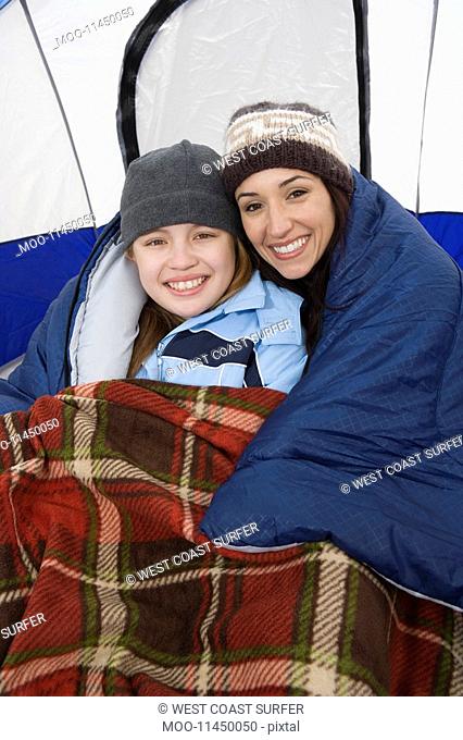 Mother and daughter embracing in tent portrait