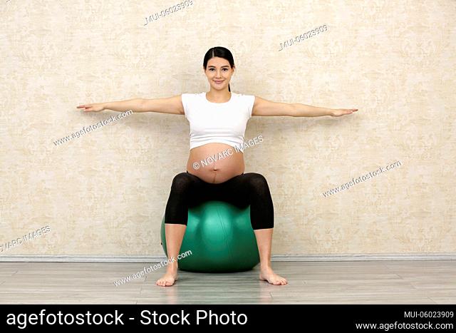 Pregnant woman does fitness exercises