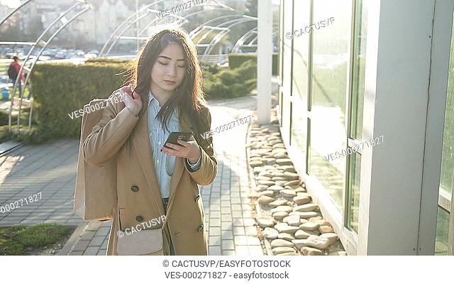 Elegant asian girl surfing the net with smartphone
