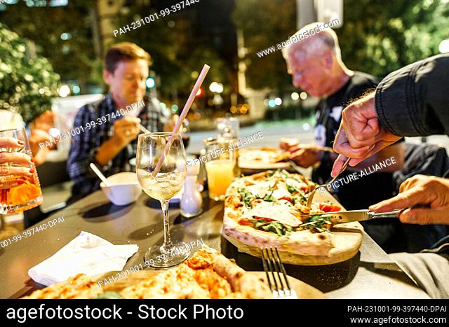 PRODUCTION - 29 September 2023, Hesse, Frankfurt/Main: People sit in the outdoor area of a restaurant in the city center
