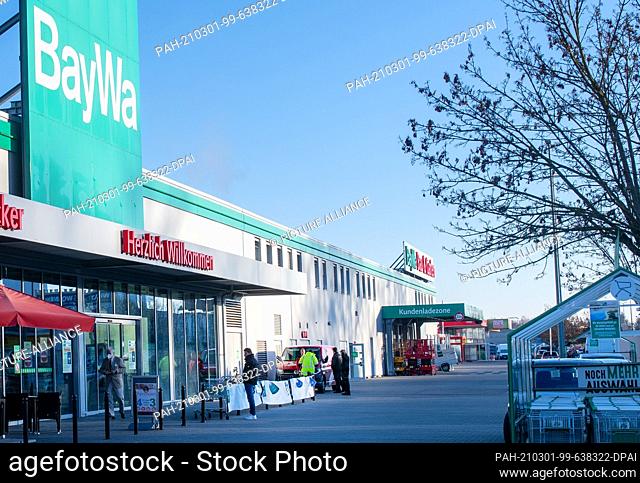 01 March 2021, Bavaria, Neu-Ulm: Few customers stand in front of a BayWa DIY store at the start of business. In Neu-Ulm, Bavaria