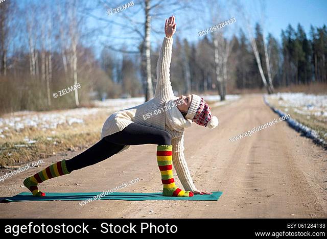 Young attractive woman practicing yoga on the rural road.Outdoor activity. Practice yoga asana. Healthy lifestyle. Pretty female sport girl workout exercise