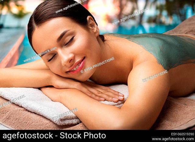 woman with blue clay mask in spa over beach