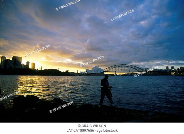 Mrs Macquaries Point. View to Opera House. Harbour. Man fishing. Sunset