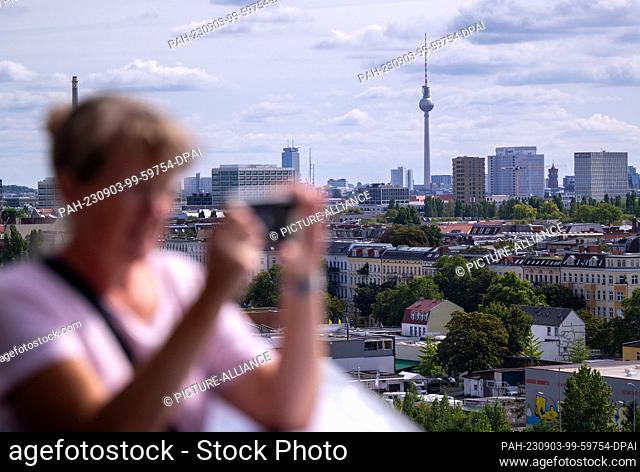 03 September 2023, Berlin: A visitor takes a photo of the view from a tower at the celebration of the 100th anniversary of Berlin's western port BEHALA