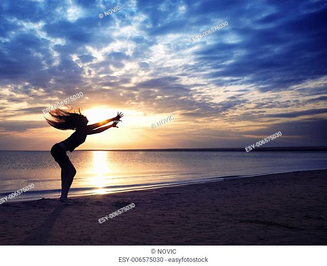 Dancing dynamic woman at the beach during sunset