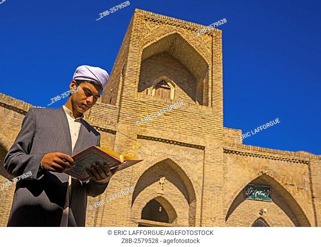 Iranian Shiite Student In The Courtyard Of An Old Caravanserai Turned Into Madrassah Reading The Koran, Golestan Province, Karim Ishan, Iran