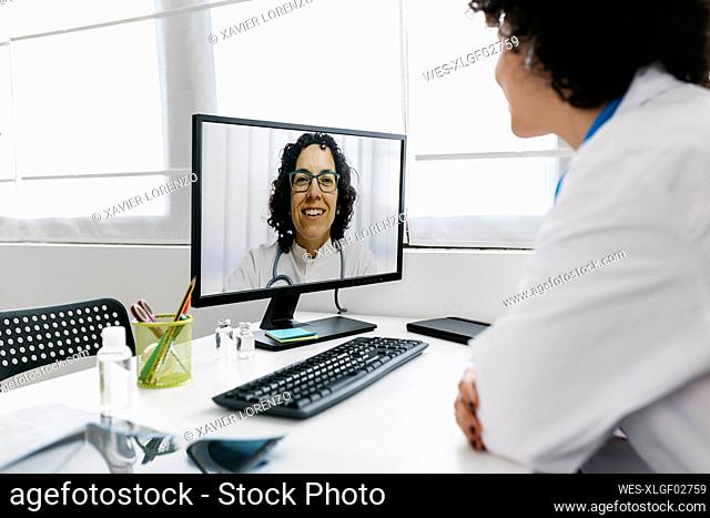 Doctor on video call with colleague through desktop PC at clinic
