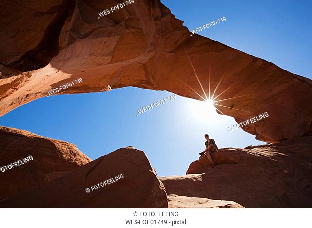 USA, Utah, Arches National Park, Person sittting near Skyline Arch