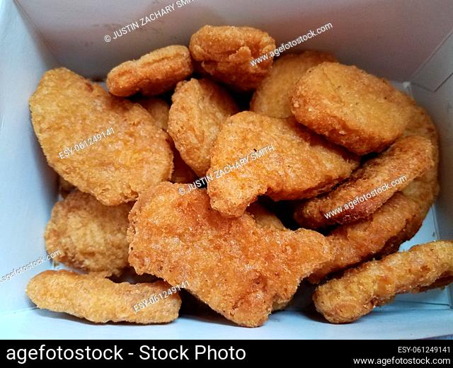 pile of brown fried chicken nuggets in white box