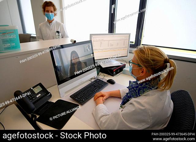 25 March 2020, North Rhine-Westphalia, Aachen: The anaesthetists Anke Offermann (r) and Sandra Dohmen sit and stand in a workroom of the ""virtual hospital...