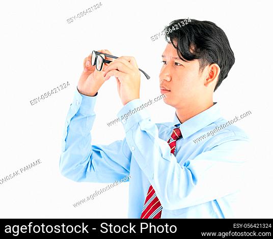 Male wearing blue shirt and red tie holding eyeglasses isolated on white background