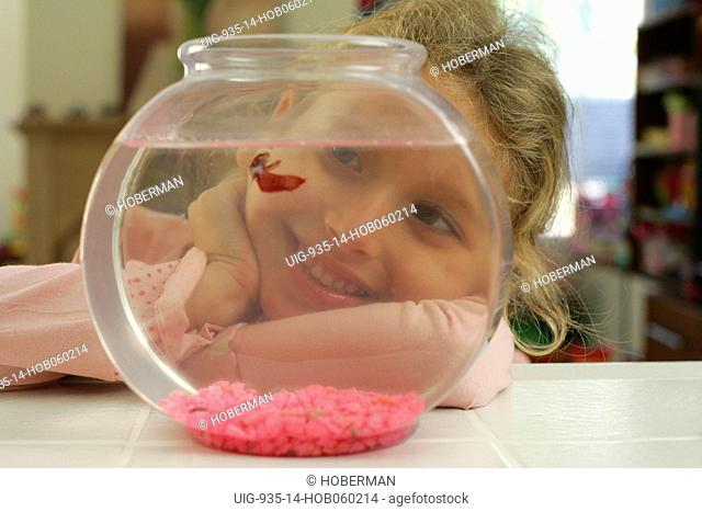 Young Girl Age 10 watching Goldfish and smiling