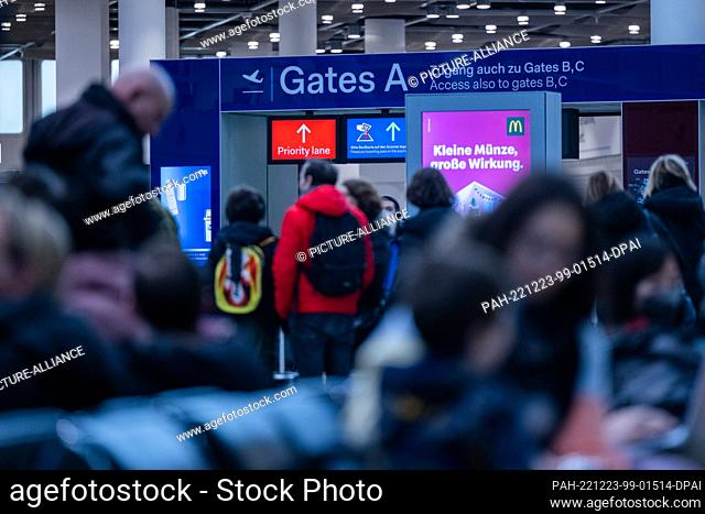23 December 2022, North Rhine-Westphalia, Duesseldorf: Travelers wait in front of the security checks of each gate in the airport. Dec