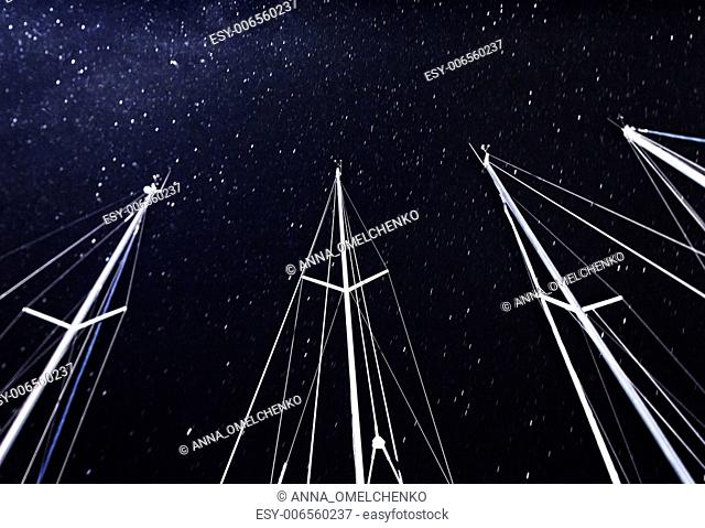 Sailboat mast on starry sky background, night travel on luxury water transport, marina in nightime, bright stars on dark sky