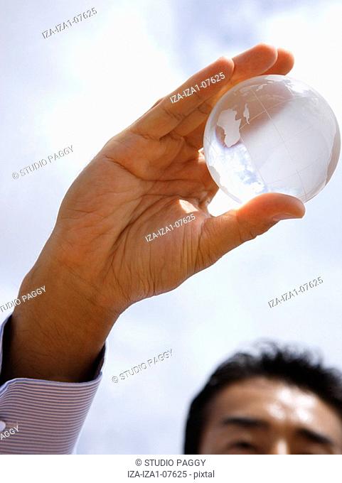 Close-up of a businessman holding a transparent globe