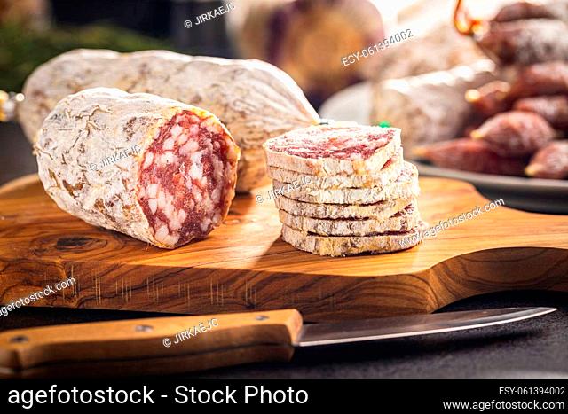 Traditional sausage with white mold. Dried sliced pork salami on a cutting board