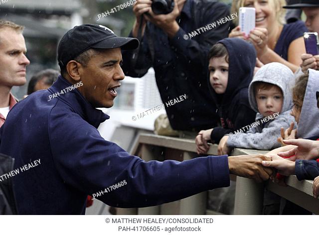 United States President Barack Obama (L) shakes hands with onlookers in front of Nancy's Restaurant in Oak Bluffs, Massachusetts on the island of Martha's...