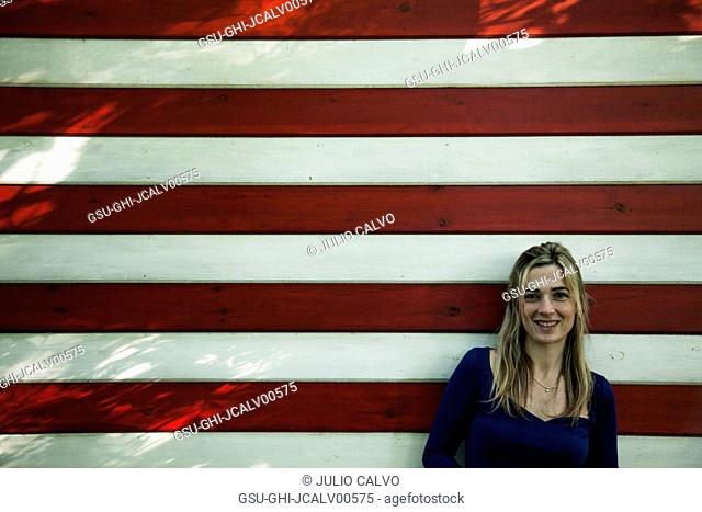 Portrait of Smiling Mid-Adult Woman Against Wall with Red and White Stripes