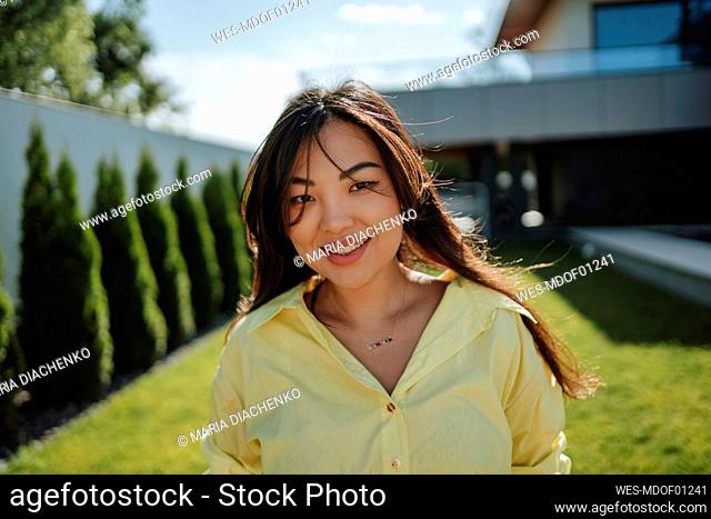 Smiling woman in backyard at sunny day