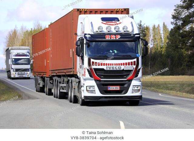 Iveco Stralis and Volvo heavy trucks pulling freight trailers along highway on a day of spring. Jokioinen, Finland. April 29, 2021